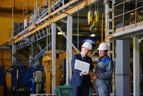 Uomini che indossano DPI e lavorano in un ambiente industriale